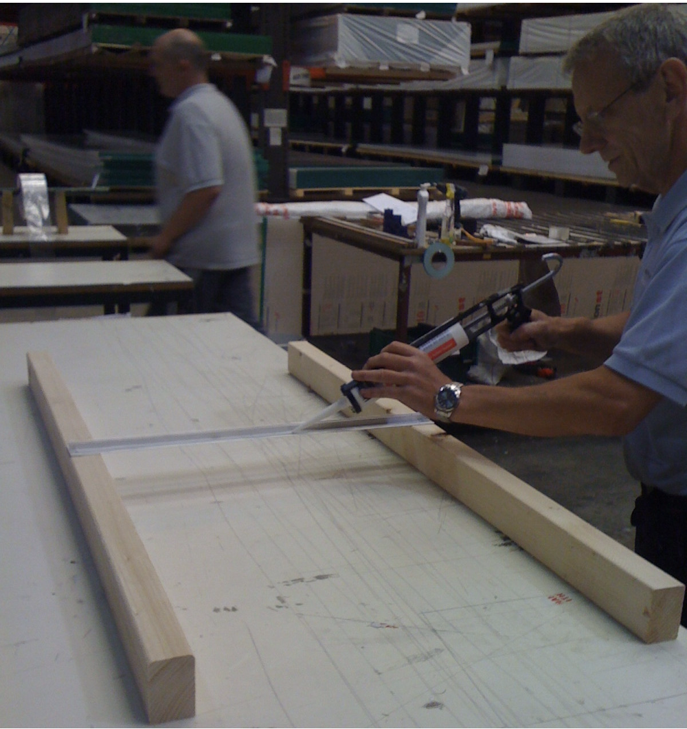 Application of low modulus silicone sealant along sides of the munting bar aluminium glazing connector