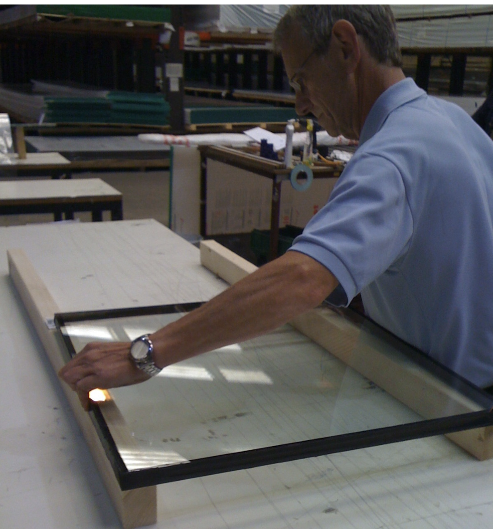 Man laying glazing panel onto glazing connector