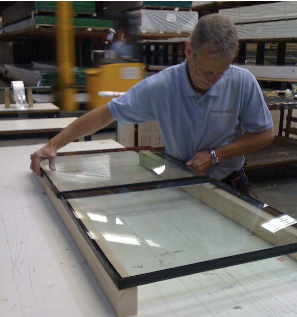 A man laying two glazing panels onto glazing connector
